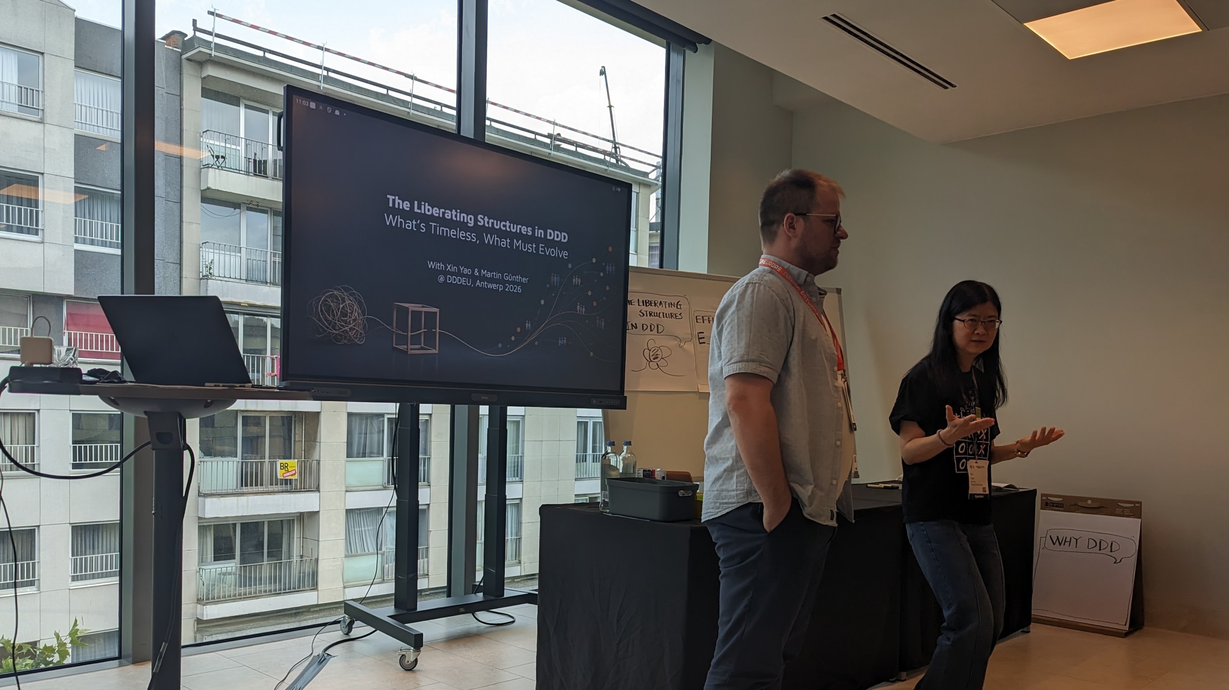 Martin Günther to the left and Xin Yao to the right, a screen showing the title of the workshop: The Liberating Structures in DDD - What's timeless, What Must Evolve